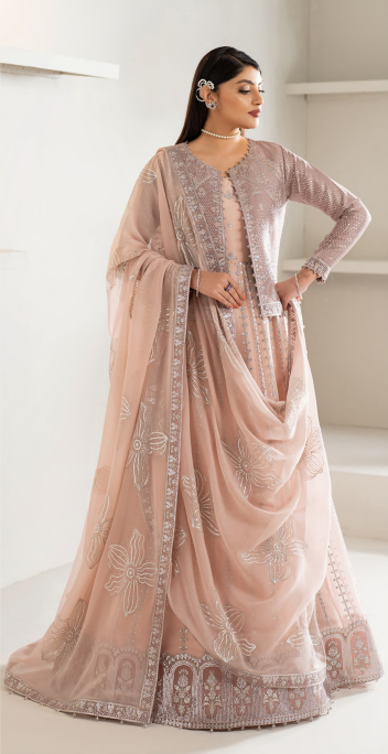 Woman wearing a light pink saree with intricate designs in a minimalistic setting