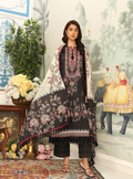 Woman wearing a black and white embroidered outfit with a floral arrangement and decorative background.