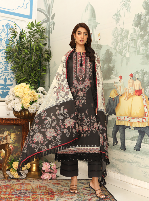 Woman wearing a black and white embroidered outfit with a floral arrangement and decorative background.