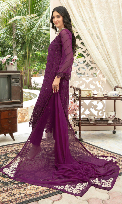 Woman wearing a purple dress with lace details in an indoor setting with decorative elements.
