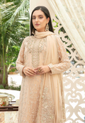 Woman in a beige embroidered outfit with a matching dupatta, standing outdoors.