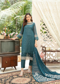 Woman in a teal embroidered outfit standing in a decorated room with a vintage television.