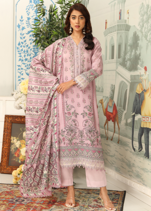 Woman wearing a pink embroidered traditional outfit with a matching dupatta in a decorative room.