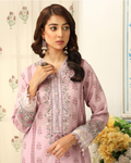 Woman wearing a pink embroidered outfit with floral background
