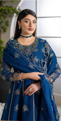 Woman wearing a blue embroidered outfit with a matching dupatta.