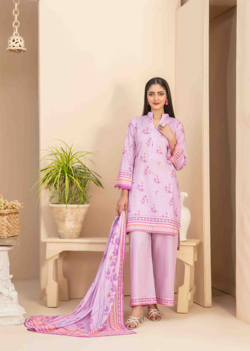 Woman wearing a light pink traditional outfit with floral patterns in a minimalistic room.