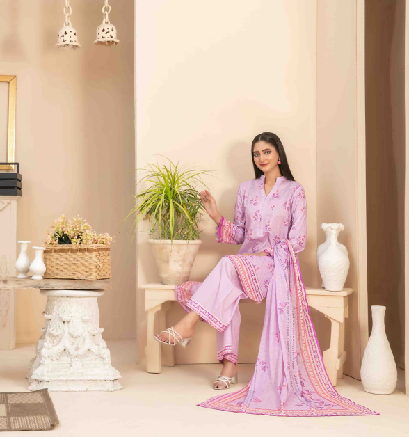 Woman in a pink traditional outfit sitting in a decorated room with plants and vases.