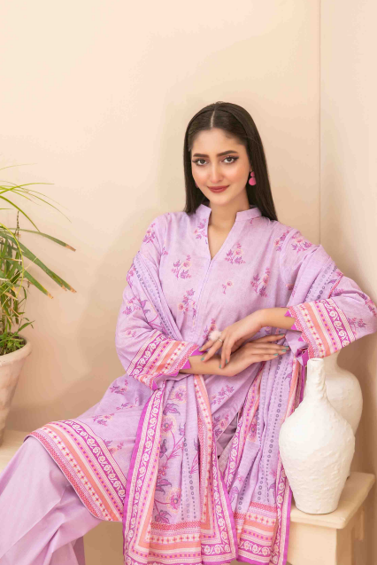 Woman wearing a pink traditional outfit with floral patterns indoors.