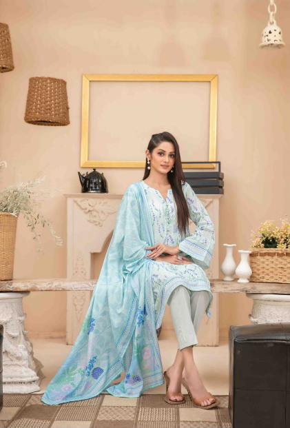 Woman in a light blue floral outfit sitting in a living room.