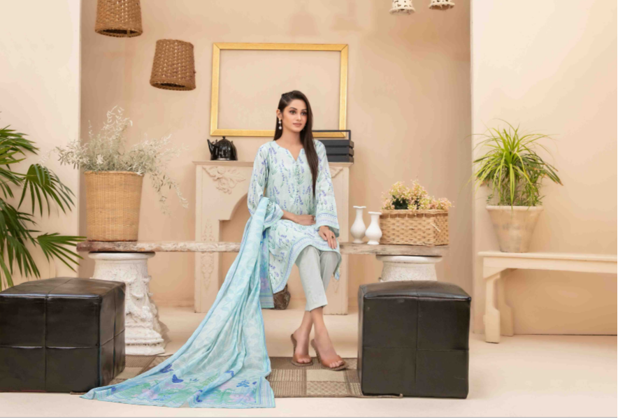 Woman in a light blue traditional outfit standing in a stylish living room.