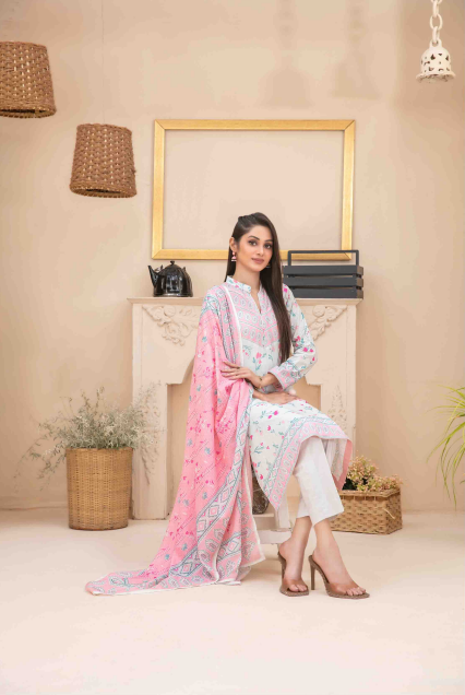 Woman in a stylish outfit with a pink dupatta in a decorated room.