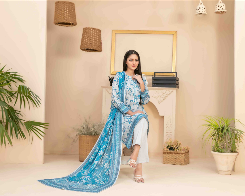 Woman in a blue and white traditional outfit sitting in a stylish room with plants and decor.