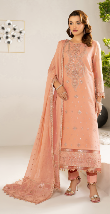 Woman wearing a peach embroidered suit with a matching dupatta in an indoor setting.