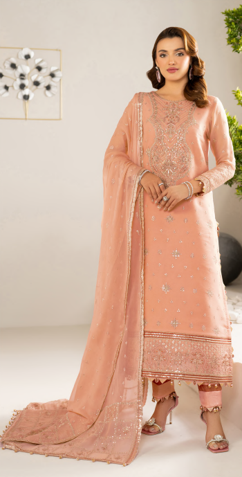 Woman wearing a peach embroidered traditional outfit with a matching dupatta on a white background