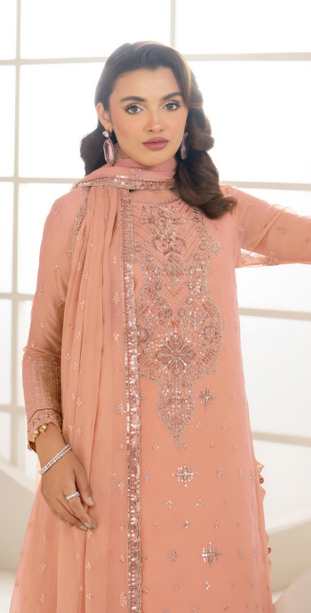 Woman wearing a peach-colored embroidered traditional outfit with a matching dupatta.