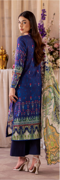 Woman in a blue embroidered dress standing in a decorated room with flowers and decor items.