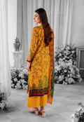 Woman in a yellow floral dress standing in a decorated room with flowers and a mirror.