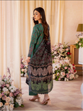 Woman in a patterned dress standing in a decorated room with flowers.
