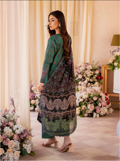 Woman in a patterned dress standing in a decorated room with flowers.