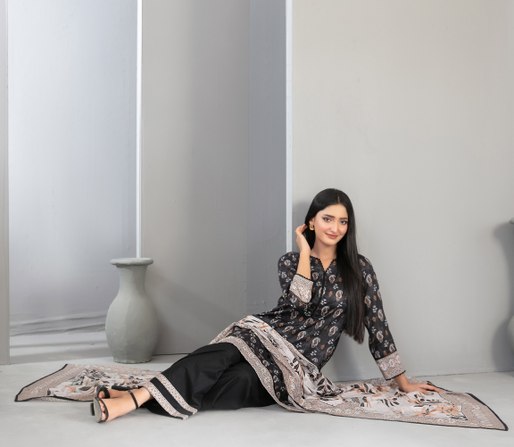 Woman sitting on the floor with a patterned scarf draped over her lap against a plain background