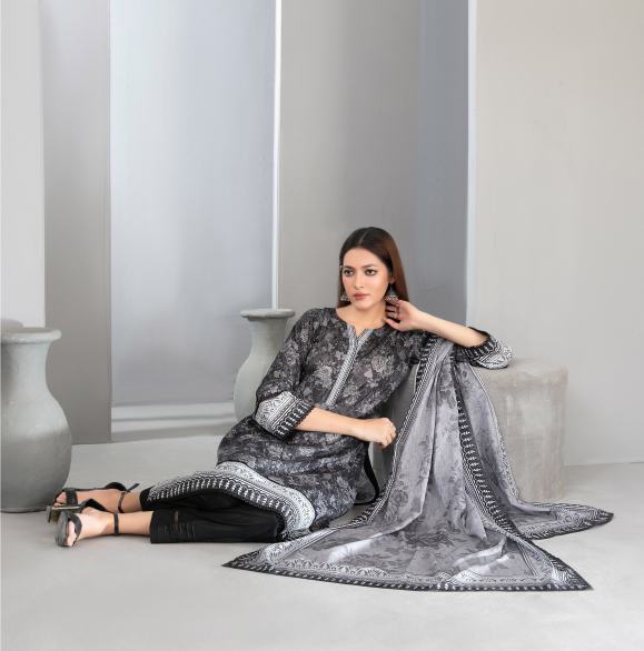 Woman in a gray traditional outfit with a matching dupatta sitting on a light-colored floor.
