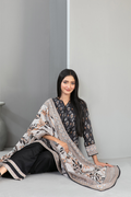 Woman sitting on a gray floor with a patterned scarf draped over her shoulders.