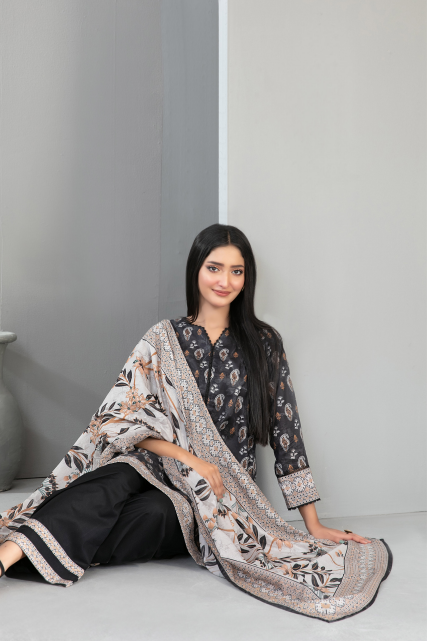 Woman sitting on a gray floor with a patterned scarf draped over her shoulders.
