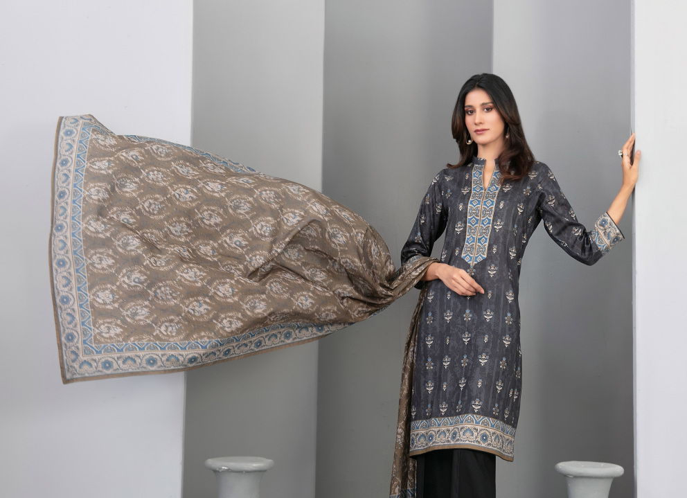 Woman holding a patterned dupatta against a plain background