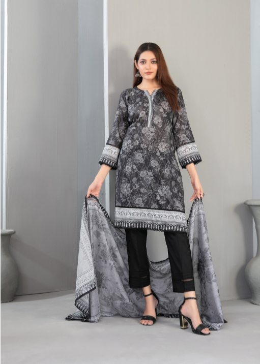 Woman wearing a gray floral dress with black pants and holding a matching dupatta against a gray background