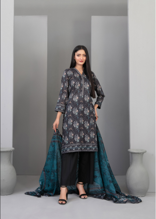 Woman wearing a dark floral dress with a blue dupatta in a minimalistic setting