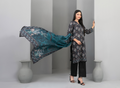 Woman holding a floral scarf in a minimalistic setting with gray vases.