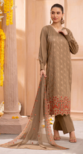 Woman in a brown traditional outfit with floral patterns standing against a beige background.