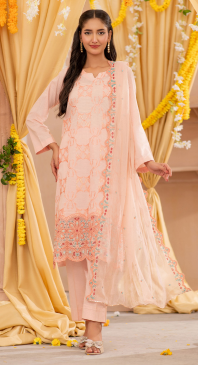 Woman in a peach embroidered outfit standing in front of yellow floral decorations