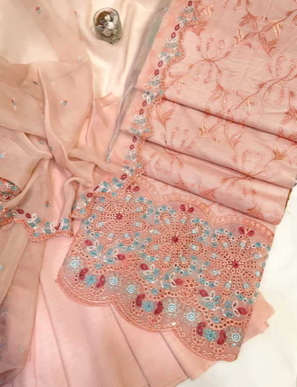 Close-up of a pink saree with intricate embroidery and embellishments.