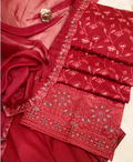 Red embroidered fabric with intricate patterns on a beige background
