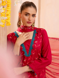Woman wearing a red and green traditional outfit with a floral background
